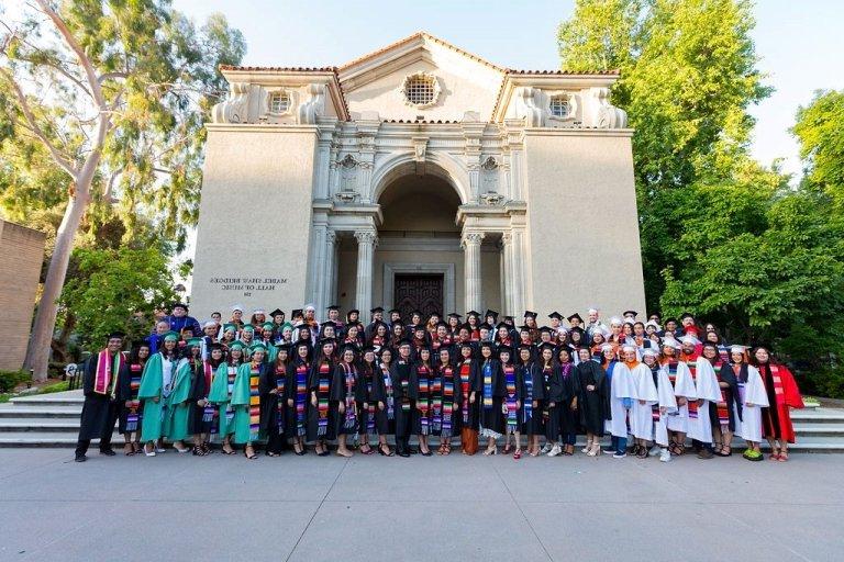 members of the chicano latino student union pose in their graduation gowns